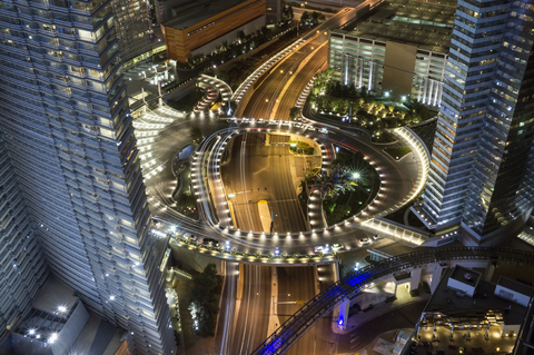 Hohe Winkelansicht der beleuchteten Autobahn inmitten von Stadtgebäuden bei Nacht, Las Vegas, Nevada, USA, lizenzfreies Stockfoto