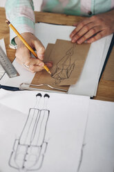 High angle view of female designer drawing sketch on paper at studio - FSIF01346