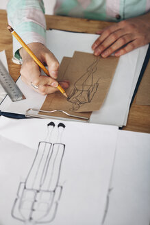 Hohe Winkel Ansicht der weiblichen Designer Zeichnung Skizze auf Papier im Studio - FSIF01346