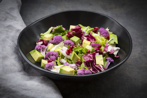 Mixed salad, purple cauliflower, avocado and pomegranate seeds stock photo
