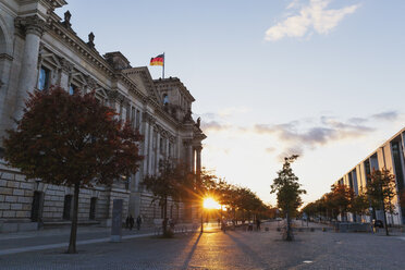 Germany, Berlin, Regierungsviertel, Reichstag building with German flags and Paul-Loebe-Building at sunset - GWF05432