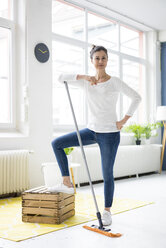 Portrait of confident woman at home wiping the floor - MOEF00798