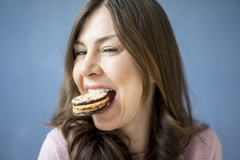 Porträt einer glücklichen Frau, die einen Kuchen isst, lizenzfreies Stockfoto