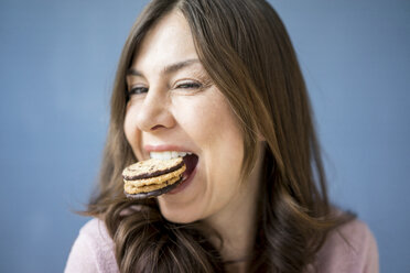 Portrait of happy woman eating a cake - MOEF00832