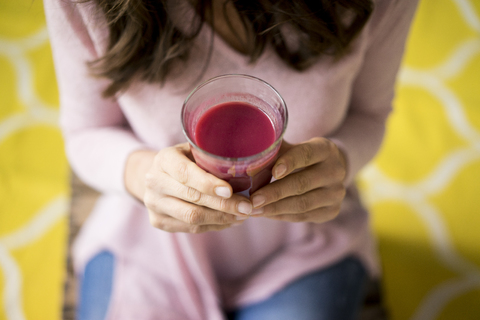 Frau hält ein Glas mit Saft, lizenzfreies Stockfoto