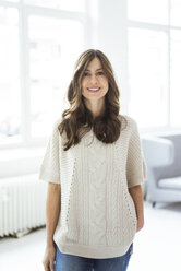 Portrait of smiling woman standing in bright room with window - MOEF00835