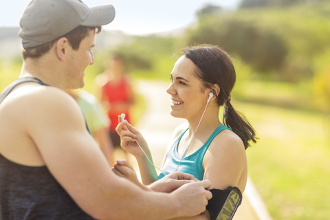 Smiling young man and woman preparing to run stock photo