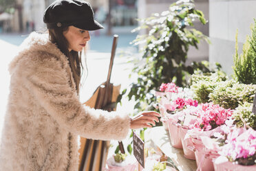 Stilvolle junge Frau beim Blumenkauf in der Stadt - AFVF00010