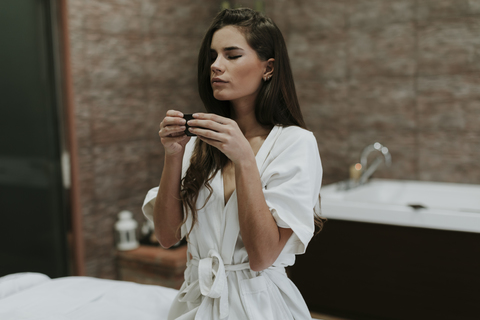 Young woman in a spa enjoying cup of tea stock photo