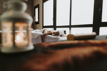 Young woman lying on lounge in a spa - OCAF00149