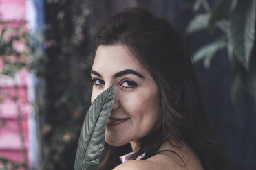Portrait of smiling young woman with leaf - AFVF00048