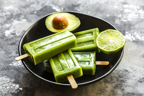 Avocado-Limetten-Eislutscher in Schale, lizenzfreies Stockfoto