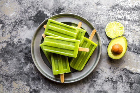 Bowl of avocado lime ice lollies stock photo