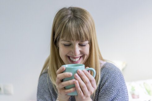 Porträt einer lachenden jungen Frau mit Kaffeetasse - AFVF00067