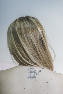Rückenansicht einer blonden Frau mit Tätowierung am Hals - AFVF00079