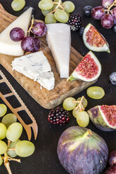 Plate with cheese, figs, grapes, blueberries, brambles, pecan, chopping board, knife - SARF03586