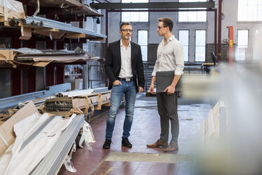 Two businessmen standing in factory storeroom - DIGF03340