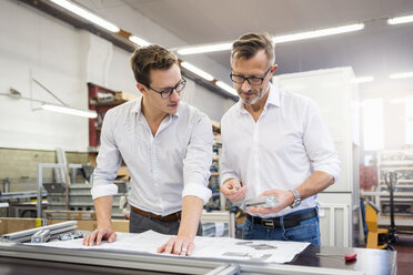 Two businessmen in factory discussing plan - DIGF03348