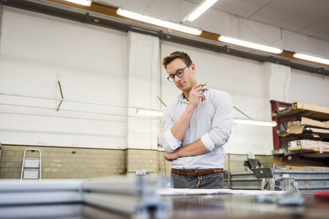 Young businessman in factory working on plan stock photo