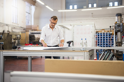 Mature businessman in factory working on plan stock photo