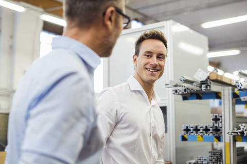 Portrait of smiling businessman with colleague in factory stock photo