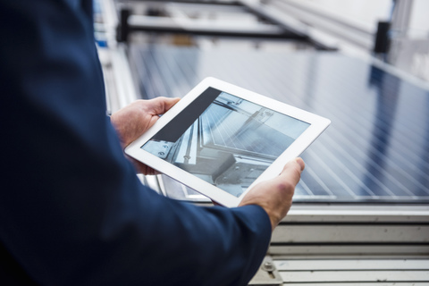 Geschäftsmann in Solarfabrik mit Tablet, lizenzfreies Stockfoto