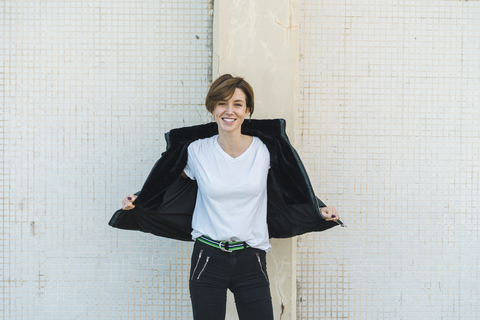 Portrait of relaxed woman taking off her jacket stock photo