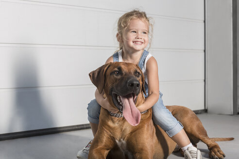 Happy cute girl looking away while sitting on dog outdoors - FSIF01393