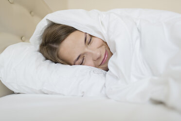Glückliche Frau schläft im Bett zu Hause - FSIF01405