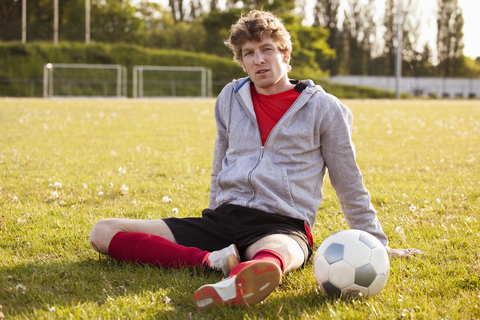 Porträt eines jungen Fußballspielers, der sich auf dem Spielfeld ausruht, lizenzfreies Stockfoto