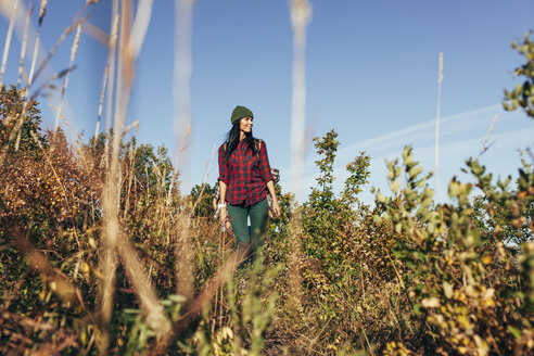 Young woman looking away while hiking in forest - FSIF01511