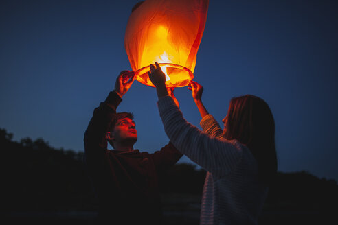 Low angle view of hikers releasing paper lanterns - FSIF01528