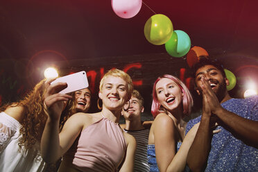 Niedriger Winkel Porträt der glücklichen Frau, die Selfie mit Freunden im Hof - FSIF01563