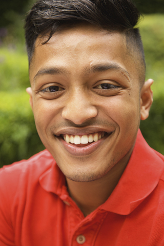 Nahaufnahme eines glücklichen jungen Mannes im Garten, lizenzfreies Stockfoto