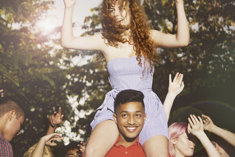 Man carrying female friends while enjoying party at yard stock photo