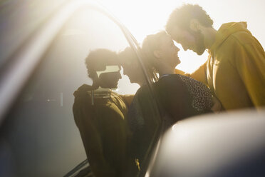 Seitenansicht eines romantischen Paares, das sich an ein Auto lehnt - FSIF01593