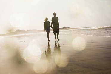 Full length of couple holding hands while walking at beach - FSIF01600