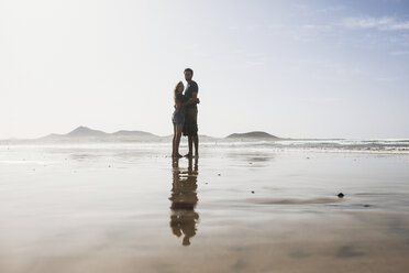 Full length of loving couple embracing at beach on sunny day - FSIF01601