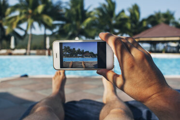 Tiefschnitt eines Mannes, der ein Schwimmbad in einem Touristenort fotografiert - FSIF01611