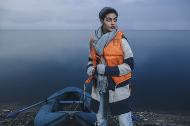 Teenager-Mädchen mit aufblasbarem Floß auf einem See stehend - FSIF01624