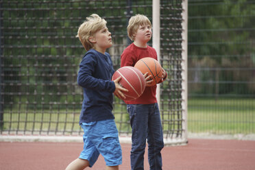 Jungen halten Basketbälle und schauen auf das Spielfeld - FSIF01642