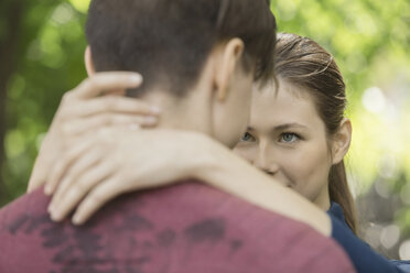 Woman looking at boyfriend while embracing in park - FSIF01655