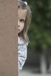 Portrait of girl standing behind wall - FSIF01659