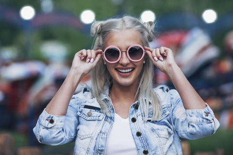 Porträt einer fröhlichen, modischen jungen Frau mit Sonnenbrille, lizenzfreies Stockfoto