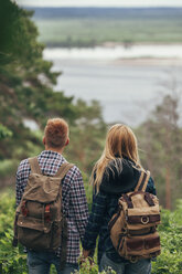 Rear view of couple wearing backpack standing in forest - FSIF01694