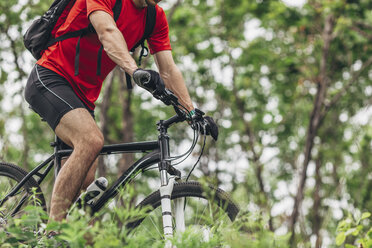 Low section of man with mountain bike in forest - FSIF01723