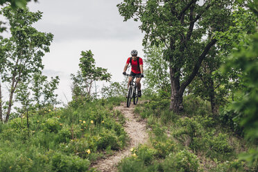 Mann fährt Mountainbike auf unbefestigter Strecke - FSIF01725