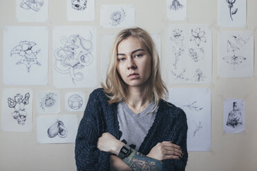 Porträt eines selbstbewussten Tätowierers, der vor einem Entwurf im Kunststudio steht - FSIF01736