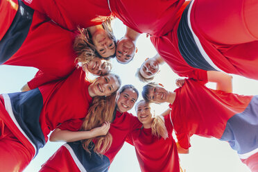 Directly below shot of soccer players huddling against clear sky - FSIF01739