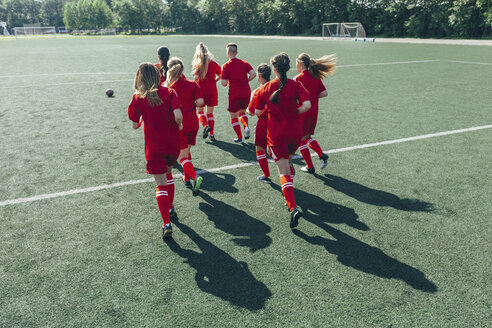 Rear view of soccer players running on field - FSIF01741